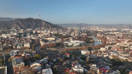Aerial panoramic view of Tbilisi, Georgia, with the Kura River, city center, and Mount Mtatsminda