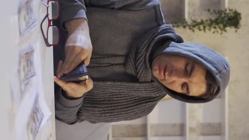 Man Counting Money at Table Indoors During Daytime