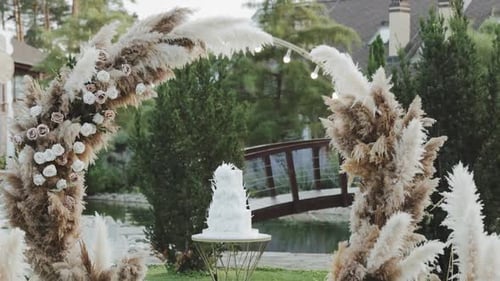Elegant Wedding Cake Displayed Outdoors Near Pond