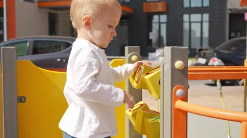 Little baby boy playing with colorful abacus and bricks on the playground