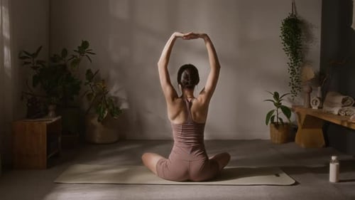 Woman Doing Yoga Stretch on Mat in Studio