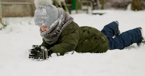 Child Playing in the Snow During Winter