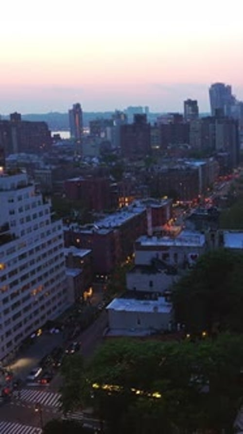 Evening New York starting to light lights at dusk. Avenues with multiple cars moving by.