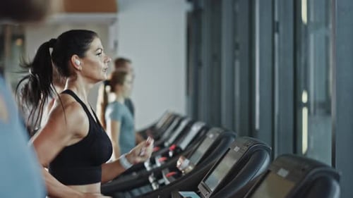 Beautiful Athletic Sports Woman Wearing Wireless Headphones, Listens to a Podcast or Sport Music Pl