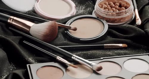 Professional Decorative Makeup Products Rotating on Black Fabric