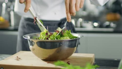 In a Famous Restaurant Cook Prepares Salad. Working in a Big Modern Kitchen.