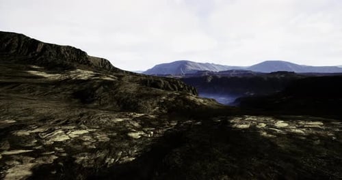 Rugged Landscape with Mountains and Valley Under a Cloudy Sky