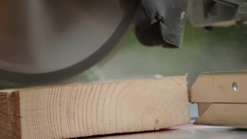 Carpenter Accurately Cuts Out a Wooden Billet on a Miter Saw in Closeup