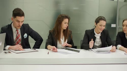 Diverse Team Reviews Documents in Modern Office