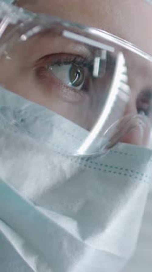 Close-Up of Healthcare Worker in Protective Goggles, Mask and Cap