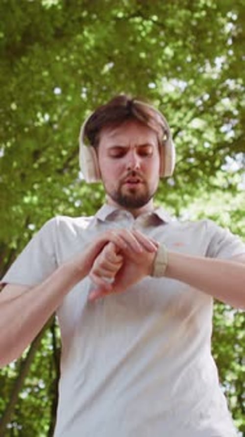 From Below of Athletic Fitness Sport Runner Man Training Marathon Run Listening Music in Headphones