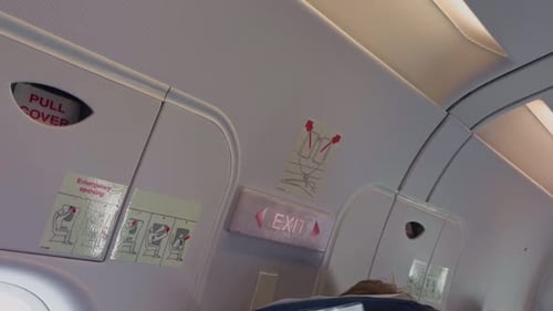 An Aircraft Cabin View Showing Essential Emergency Instructions and Detailed Safety Signage for