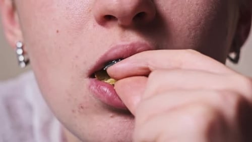 Woman Eats Crispy Potato Chip in Extreme Close Up