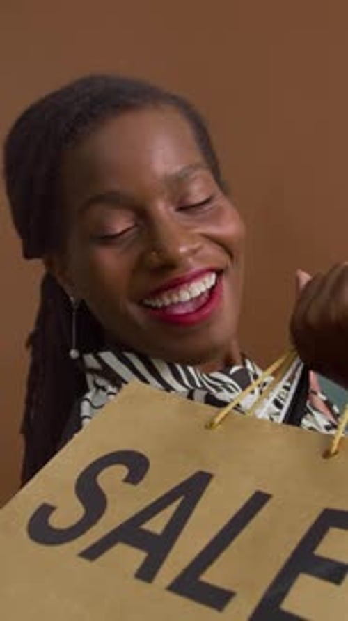 Woman Smiling Holding Shopping Bags with 'SALE'