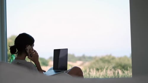 Home office remote work Young professional engaged in a business call with a scenic backdrop using h