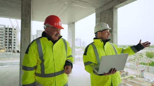 Civil Engineer and Architect with Laptop are Examining Underconstruction Building Building