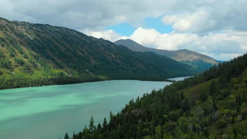 Aerial View of Alpine Turquoise Lake and Forested Mountains Media
