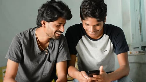 Young Men Laughing While Looking at Mobile Phone