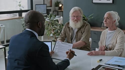 Financial Advisor Explaining Agreement Terms to Senior Couple