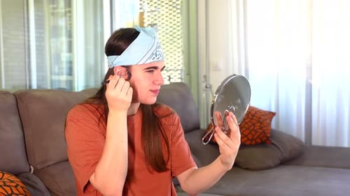 Young Adult Applying Makeup with Brush and Mirror