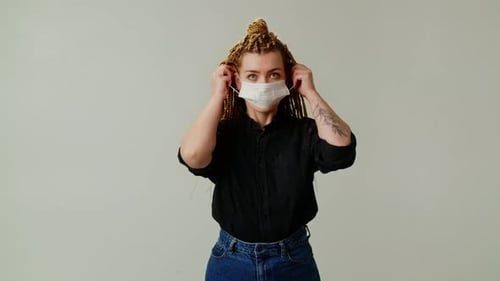 A Girl with Pigtails Wears a Medical Mask on Her Face As Protection Against a Deadly Virus