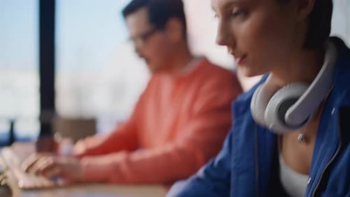People Typing on Laptops at a Modern Workplace