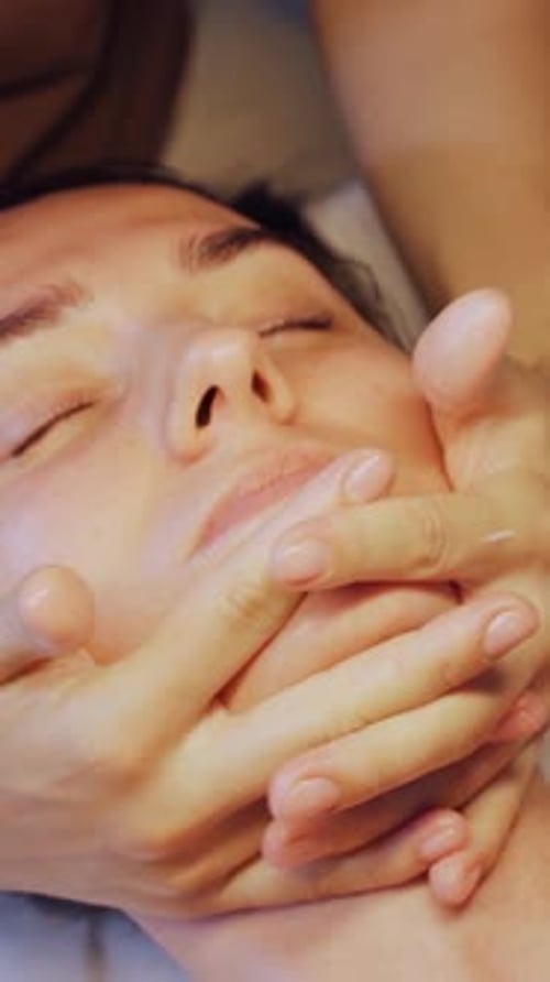 Woman Receiving Relaxing Facial Massage in Spa Setting