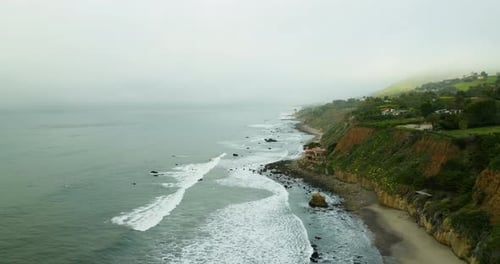 Drone flyover waves crashing on rocky beach