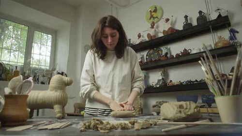 Young Woman Shaping Clay in Pottery Studio
