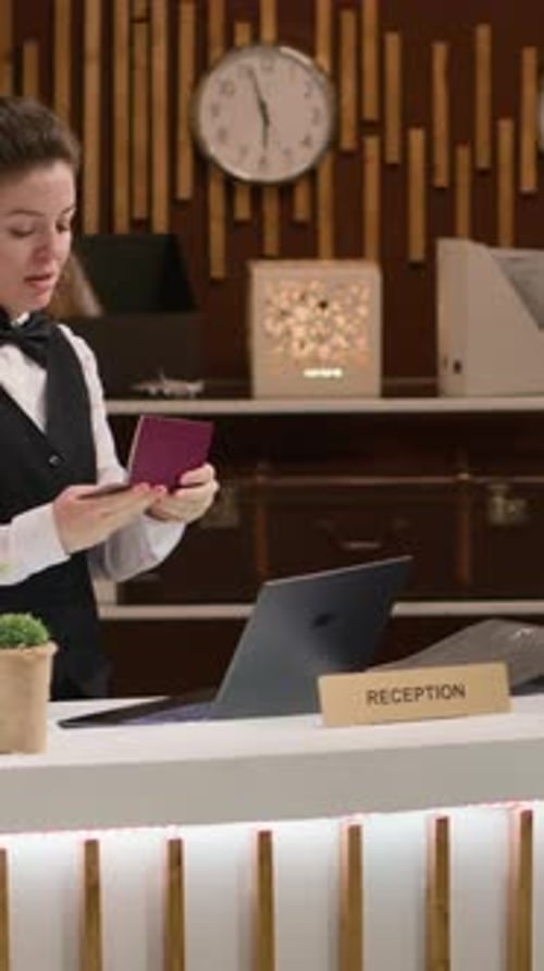 Hotel Receptionist Checks Passport at Modern Lobby Desk