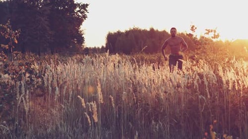 Young Man is Fast Running on Summer Meadow Lovely Sunset Light