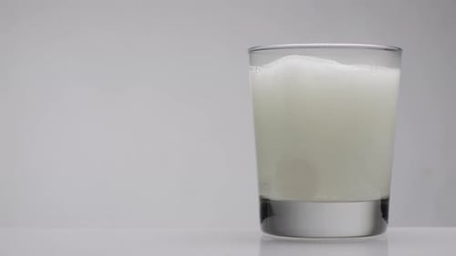 Effervescent Tablet Dissolving Quickly in Glass of Water
