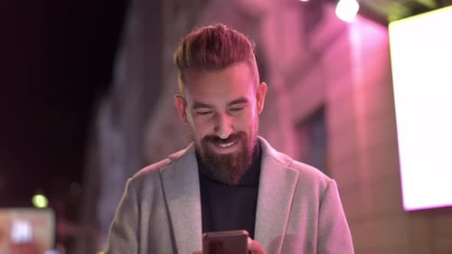 Smiley Caucasian Businessman Using Phone Texting at the City