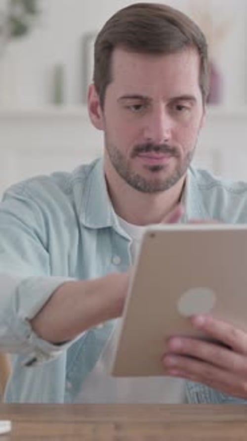 Young Man Celebrating Success on Tablet in Office, Vertical Video