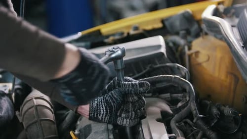 Car Auto Service Mechanic Unscrews Detail of Car