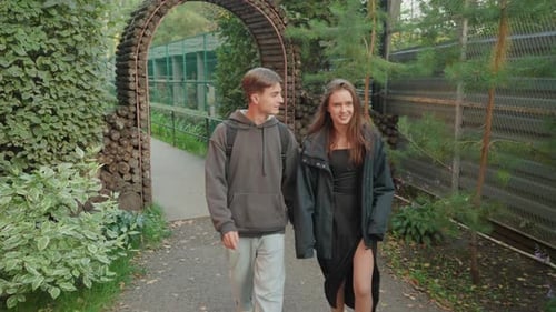 Loving Couple Strolling Through Park Holding Hands Together