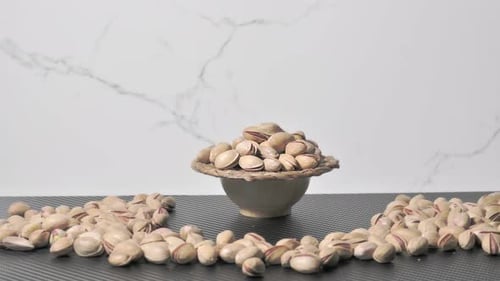Pistachios in Bowl and Scattered on Surface