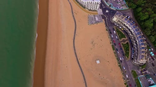 Birdseye panning view, Folkestone town beach front scenery, ocean water