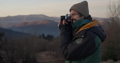 Man Photographs Mountain Landscape with Vintage Camera