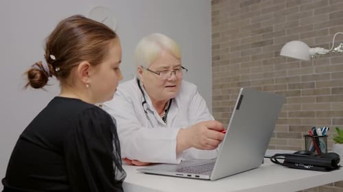 Doctor Explains Diagnosis to Child on Laptop
