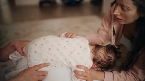 Loving Family with Infant Indoors on Exercise Ball