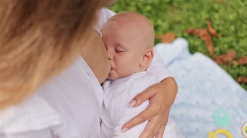 Madre amamantando a su bebé en el parque