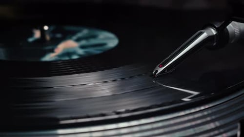 Close-up of a vinyl record spinning on a turntable with the needle in frame.