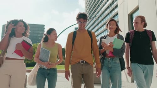 A boy and a girl walking and talking. students going to classes with a group of college friends