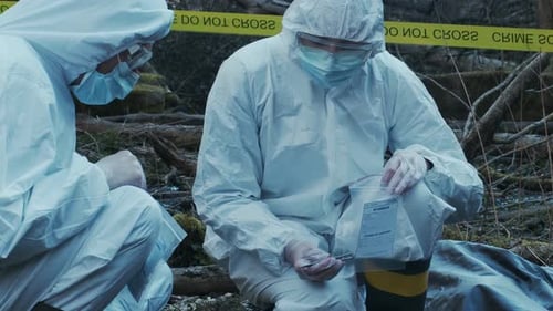 Forensic Specialist Working in the Forest Police Criminalists Collecting Evidence and Making