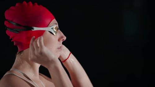 Athletic Woman Swimmer In Red Swimsuit Swimming Cap And Goggles In Pool Medium Side Portrait