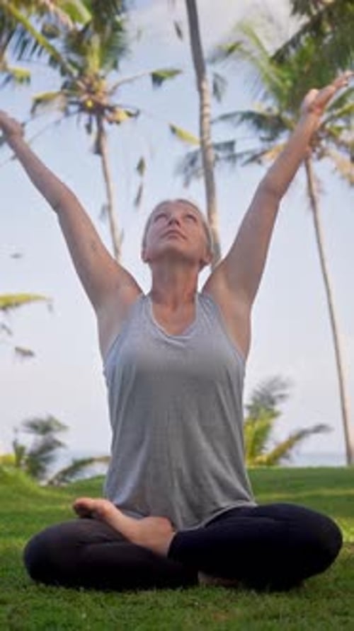Woman Practicing Yoga Underneath Tropical Palm Trees