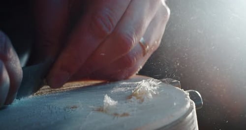 Slow motion macro of master artisan luthier painstaking detailed work on wood violin in a workshop