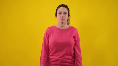 Woman Looking Directly at Camera on Yellow Background