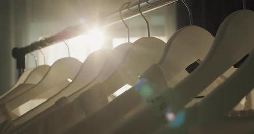 Clothing Hanging in Sunlight on Wooden Hangers